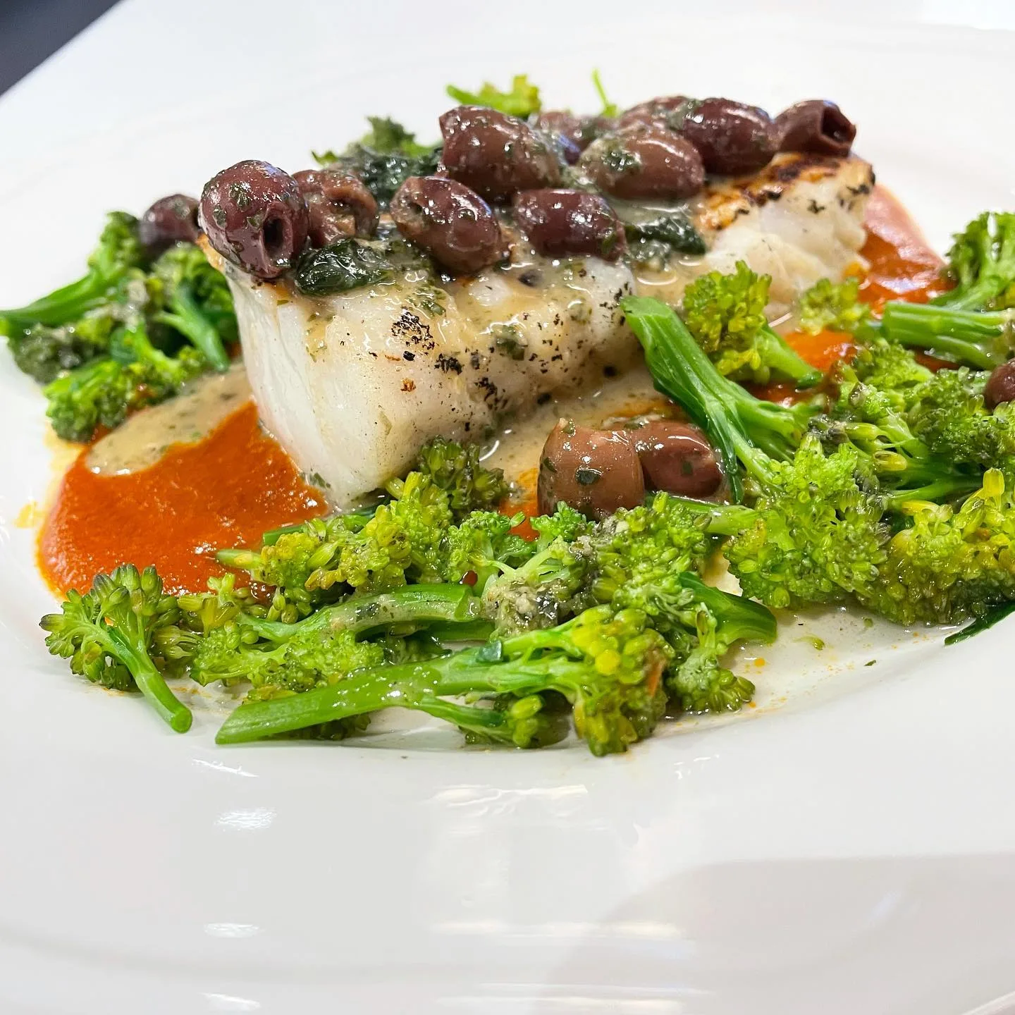 Fish with greens, olives and tomato sauce