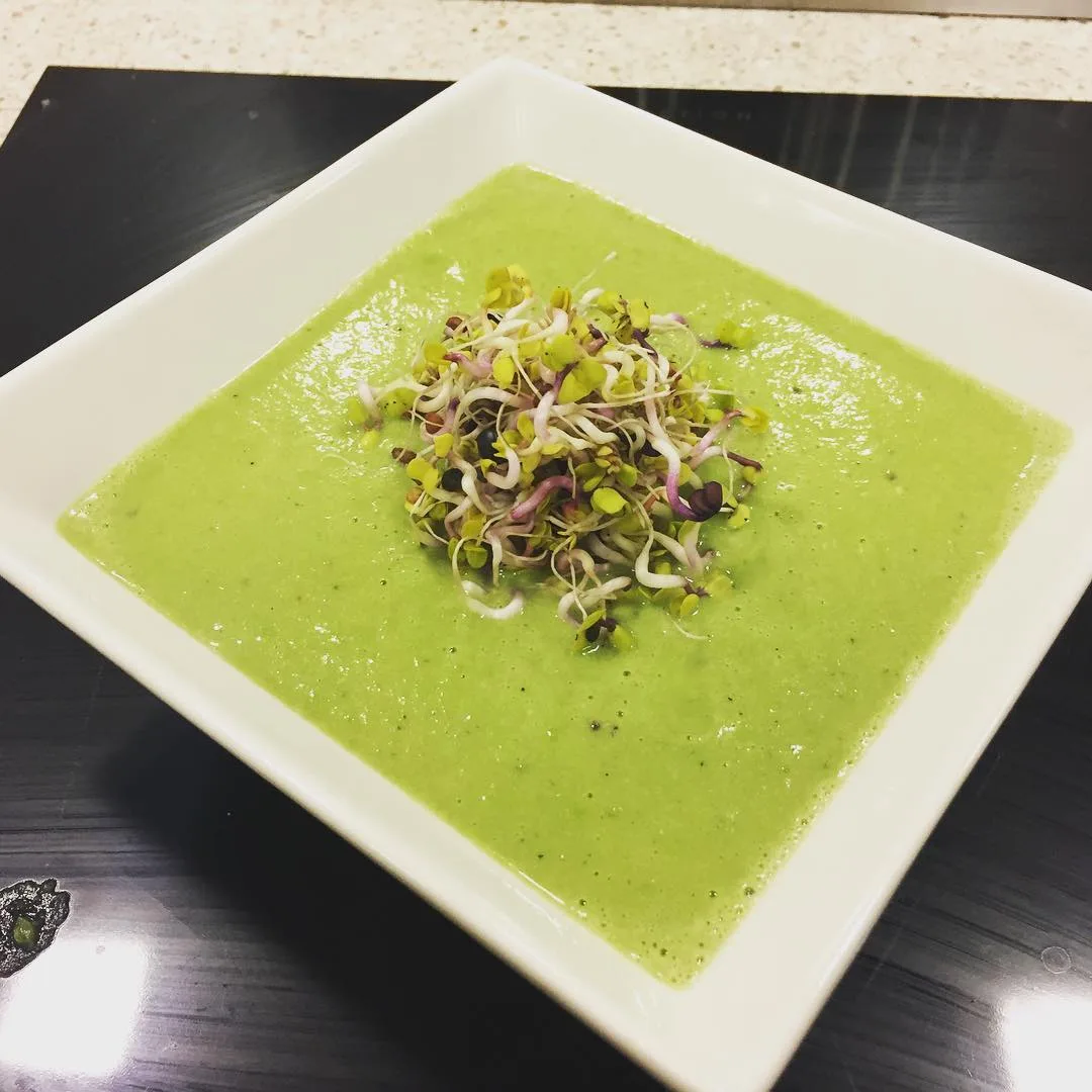 Bright green soup topped with sprouts