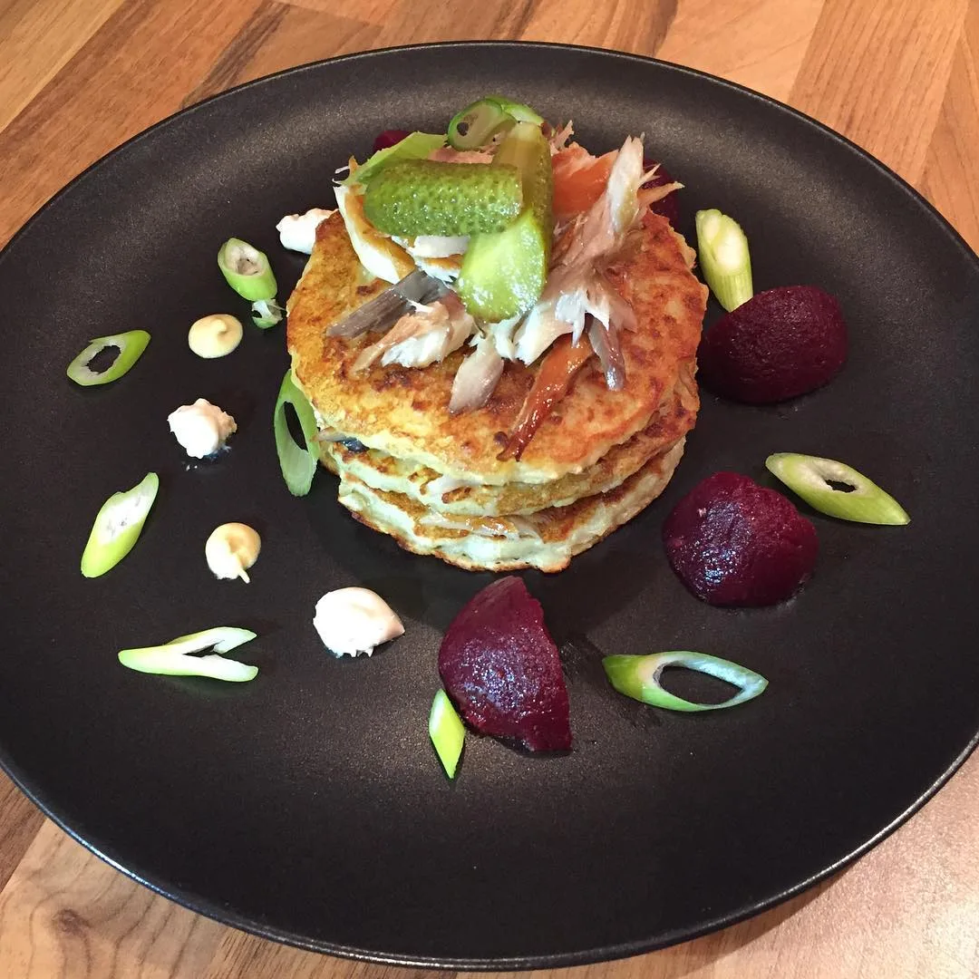 A layered savoury course on a dark plate