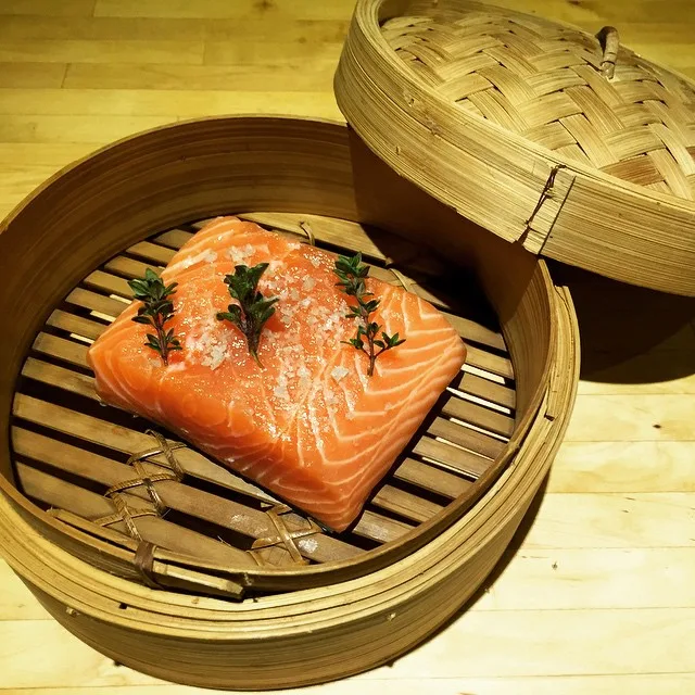 Salmon steaming in a bamboo basket